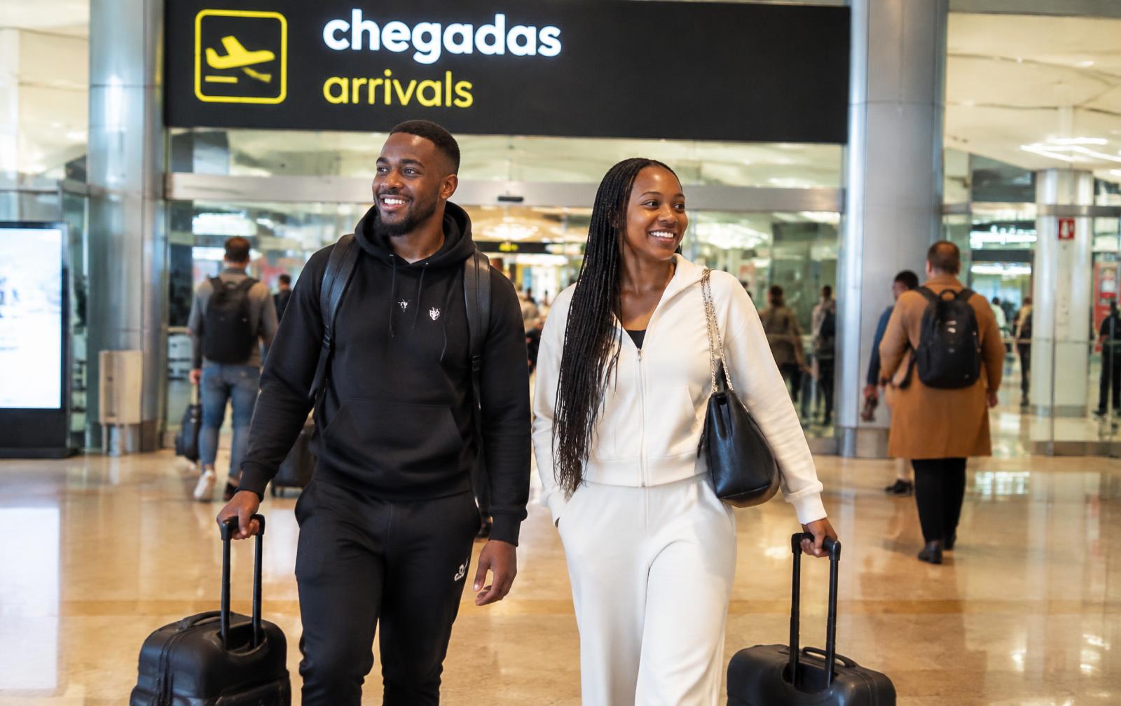 Casal angolano sorridente a chegar a Portugal